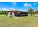 Enclosed sunroom with tiled roof and multiple windows overlooking the grassy yard and perimeter fencing at 5549 Aragon Ave, De Leon Springs, FL 32130