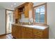 Convenient wet bar area with wooden cabinets, sink, and a window providing natural light, ideal for entertaining guests at 5549 Aragon Ave, De Leon Springs, FL 32130