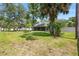 Expansive backyard featuring a lush lawn, mature trees, and a screened-in porch, perfect for outdoor living at 6 Leisure Wood Way, Ormond Beach, FL 32174