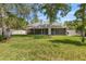Expansive backyard featuring the back of the house and a screened in patio at 6 Leisure Wood Way, Ormond Beach, FL 32174