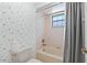 Cozy bathroom featuring decorative wallpaper, toilet, and bathtub with shower at 6 Leisure Wood Way, Ormond Beach, FL 32174