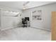 Spacious bedroom featuring carpeted floors, and a desk with an office chair by the window at 6 Leisure Wood Way, Ormond Beach, FL 32174
