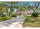 Stately two-story brick home with a circular driveway and mature trees, creating a grand and welcoming entrance at 6 Leisure Wood Way, Ormond Beach, FL 32174