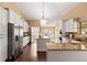 Bright kitchen with an island, granite countertops, stainless steel appliances, and white cabinetry at 6 Leisure Wood Way, Ormond Beach, FL 32174