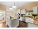Bright kitchen with an island, granite countertops, stainless steel appliances, and white cabinetry at 6 Leisure Wood Way, Ormond Beach, FL 32174