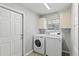 Well lit laundry room featuring a washer, dryer and lots of storage cabinets for supplies at 6 Leisure Wood Way, Ormond Beach, FL 32174