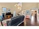 Cozy living room with high ceilings, a chandelier, hardwood floors, and a black leather sofa at 6 Leisure Wood Way, Ormond Beach, FL 32174
