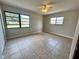 This bedroom is illuminated by natural light and has large tile flooring and a ceiling fan at 600 S Parkview Ave, Orange City, FL 32763