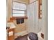 Bathroom with a toilet, shower, and a sink under a window with curtains at 601 N Garfield Ave, Deland, FL 32724