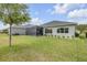 Backyard view showing the screened-in lanai and well-maintained lawn at 660 Mosaic Blvd, Daytona Beach, FL 32124