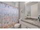 Well-lit bathroom featuring a shower with a themed curtain and granite vanity at 660 Mosaic Blvd, Daytona Beach, FL 32124