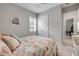 Comfortable bedroom featuring neutral walls, seashell bedding, and shuttered windows at 660 Mosaic Blvd, Daytona Beach, FL 32124