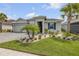 Inviting single-story home with a three-car garage, lush lawn, beautiful landscaping, and decorative shutters at 660 Mosaic Blvd, Daytona Beach, FL 32124
