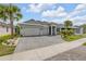 Charming single-story home featuring a three-car garage, beautiful landscaping, and a stone driveway at 660 Mosaic Blvd, Daytona Beach, FL 32124
