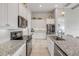 Kitchen featuring white cabinets, stainless steel appliances, granite countertops, and a center island with sink at 660 Mosaic Blvd, Daytona Beach, FL 32124