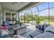 A covered lanai is shown with comfortable seating, fan, screened enclosure and views of backyard and lake at 660 Mosaic Blvd, Daytona Beach, FL 32124