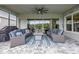 Covered lanai with seating, ceiling fan, screened enclosure, view of backyard and lake at 660 Mosaic Blvd, Daytona Beach, FL 32124