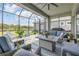 Outdoor lanai featuring comfortable seating, a screened enclosure, and scenic views of the backyard and lake at 660 Mosaic Blvd, Daytona Beach, FL 32124