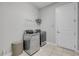 Clean laundry room with modern washer and dryer and storage shelving at 660 Mosaic Blvd, Daytona Beach, FL 32124
