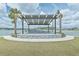 Outdoor lakeside pavilion with decorative stone and seating area, set in a grassy landscape at 660 Mosaic Blvd, Daytona Beach, FL 32124