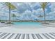 Community pool with zero entry access, lounge seating, and palm trees against a sunny sky at 660 Mosaic Blvd, Daytona Beach, FL 32124