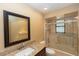 Bathroom featuring a granite vanity, framed mirror, and tiled shower and tub at 68 Spring Lake Dr, Debary, FL 32713