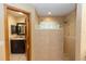 Bathroom featuring walk-in shower with stone accents, glass brick window, and dark cabinets at 68 Spring Lake Dr, Debary, FL 32713