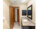Bathroom featuring a granite vanity, framed mirror, and wooden paneled door at 68 Spring Lake Dr, Debary, FL 32713