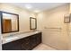 Bathroom featuring double granite vanity with dark cabinets, tile floors, and modern fixtures at 68 Spring Lake Dr, Debary, FL 32713