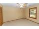 Carpeted bedroom featuring a ceiling fan, a window, and a door to the closet at 68 Spring Lake Dr, Debary, FL 32713