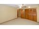 Carpeted bedroom featuring a ceiling fan and closet doors, with an open door leading into another room at 68 Spring Lake Dr, Debary, FL 32713