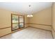 Well-lit dining room with tile floors, classic chandelier, and large window, perfect for Gathering meals and entertaining guests at 68 Spring Lake Dr, Debary, FL 32713