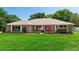 Charming single-story brick home with a well-manicured lawn and a vibrant red front door, creating an inviting first impression at 68 Spring Lake Dr, Debary, FL 32713