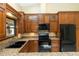 Well-appointed kitchen featuring wood cabinets, granite countertops, black appliances, and a functional layout for cooking at 68 Spring Lake Dr, Debary, FL 32713