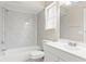 Clean bathroom featuring a shower-tub combo with sleek, updated marble-like tiling and a white vanity at 688 Cumberland Rd, Deland, FL 32724