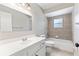Updated bathroom with a large vanity and mirror, featuring a tiled shower-tub and a window at 688 Cumberland Rd, Deland, FL 32724