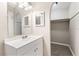 Bright bathroom with a walk-in closet featuring a large vanity with ample lighting and carpeted floor at 688 Cumberland Rd, Deland, FL 32724