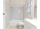 Tiled bathroom featuring a shower-tub combo with sleek, updated marble-like tiling and a white vanity at 688 Cumberland Rd, Deland, FL 32724