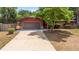Charming single-story home featuring a garage and a long driveway nestled within a lush green landscape at 688 Cumberland Rd, Deland, FL 32724