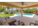Covered patio with comfortable seating overlooks the sparkling pool and lush backyard at 6917 Vintage Ln, Port Orange, FL 32128