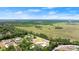 An aerial view of the property with a large green field and a small lake in the background at 793 Timothy St, Ormond Beach, FL 32174