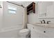 Updated bathroom with white subway tile, granite vanity, and a shower-tub combo with a decorative curtain at 793 Timothy St, Ormond Beach, FL 32174