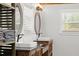 Bathroom with double vanity, oval mirrors, and window with blinds at 793 Timothy St, Ormond Beach, FL 32174