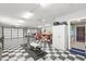 The spacious garage has a black and white checkerboard floor and ample workspace at 793 Timothy St, Ormond Beach, FL 32174