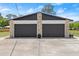 Two car garage with black doors and stone accents at 793 Timothy St, Ormond Beach, FL 32174
