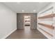 Hallway with stone accent wall leading to a bedroom, with floating shelves enhancing the modern aesthetic at 793 Timothy St, Ormond Beach, FL 32174