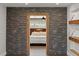 Stone accent wall hallway leads to a bedroom view, complemented by floating wood shelves for added charm at 793 Timothy St, Ormond Beach, FL 32174