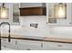 Bright kitchen features custom cabinets, stylish range hood, and sleek cooktop at 793 Timothy St, Ormond Beach, FL 32174