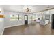 Spacious living room with wood-look floors, neutral walls, stylish lighting, and an open view to the kitchen at 793 Timothy St, Ormond Beach, FL 32174
