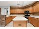 Kitchen with stainless steel appliances, wooden cabinets, white counters, and a center island at 8231 Sw 79Th Ct, Ocala, FL 34476